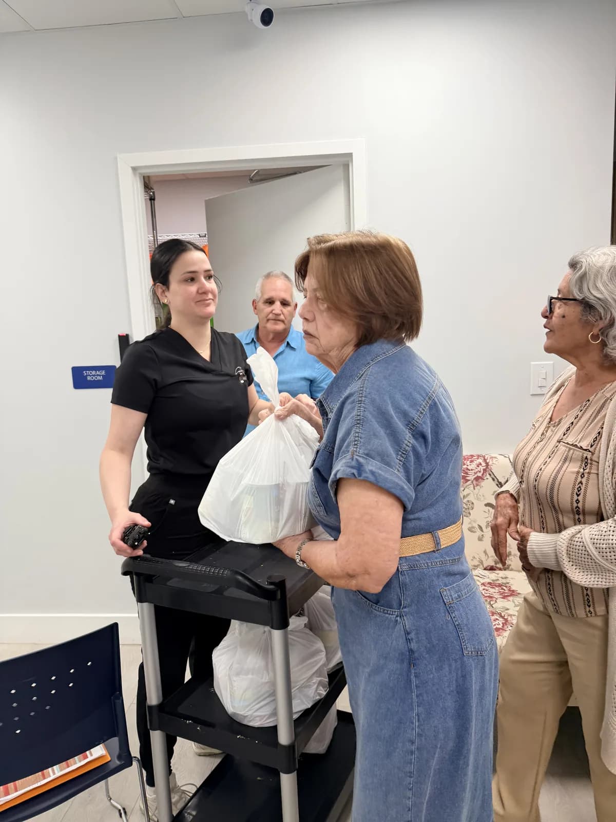 Volunteer handing a bag of groceries to a neighbor at a distribution